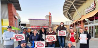Voters Set to Decide on Raise The Wage Renton in February Ballot Measure A group of about 15 campaign volunteers hold clip board and campaign signs at a mall plaza.