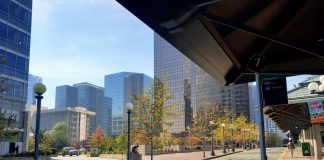 A canopy shelters the Bellevue Transit Center with downtown office towers in the background.