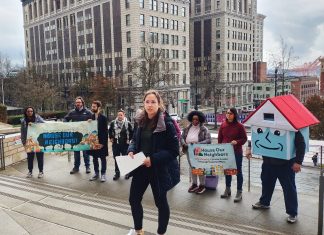 Seattle Social Housing Board Fires CEO, Taps McCoy as Interim Leader Social housing advocates stand on the steps of Seattle City Hall with their house mascot.