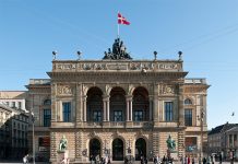 How Copenhagen is Leading the World in Sustainability Two greenish copper statues frank the entrance to the theater, which flies a Danish flag at its apex.