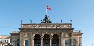 How Copenhagen is Leading the World in Sustainability Two greenish copper statues frank the entrance to the theater, which flies a Danish flag at its apex.