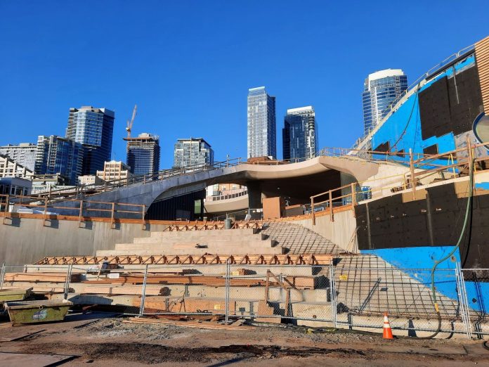 Steps are taking shape even with the concrete not yet poured. The Seattle skyline peeks in the background.