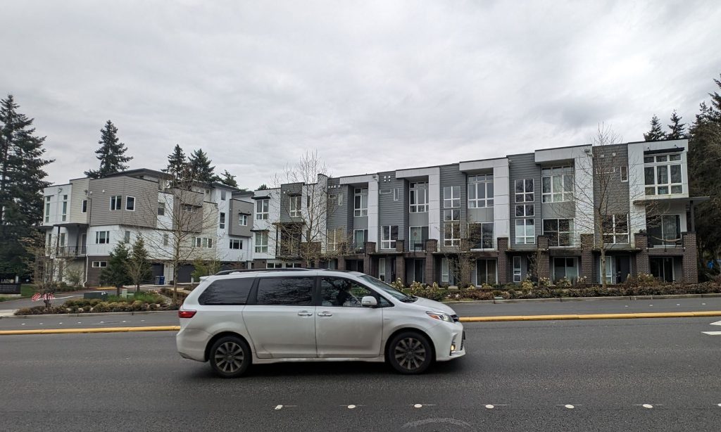 A row of newer townhomes and a minivan