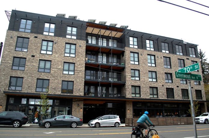 A bike whizzes by on Greenwood Avenue with a brick building in the background