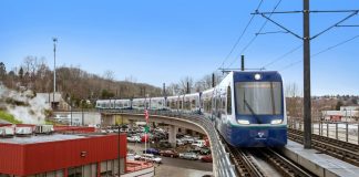 Sound Transit Speeds Up Delivery of 10 Link Cars to Handle Crowds A train makes the turn on elevated tracks near Mount Backer Station.