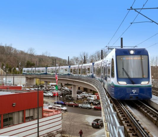 Sound Transit Speeds Up Delivery of 10 Link Cars to Handle Crowds A train makes the turn on elevated tracks near Mount Backer Station.