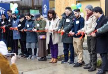 Op-Ed: Boost Seattle’s Growth Plan to Solve the Housing Crisis Eleven people hold a ribbon outside a housing project.