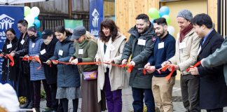 Op-Ed: Boost Seattle’s Growth Plan to Solve the Housing Crisis Eleven people hold a ribbon outside a housing project.