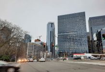 Op-Ed: Chamber Campaigns to Save SLU from Timely Light Rail A view down Denny Way shows a row of cars. The Amazon campus towers are in the background.