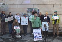 Mobility Advocates Find Support for Bigger Levy in Poll, Council Deliberates Fellow advocates stand behind Cantor and hold signs urging action on safe streets.