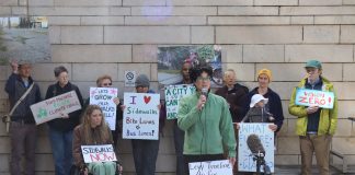 Fellow advocates stand behind Cantor and hold signs urging action on safe streets.