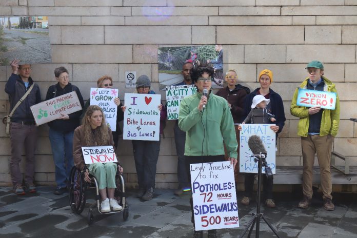 Fellow advocates stand behind Cantor and hold signs urging action on safe streets.