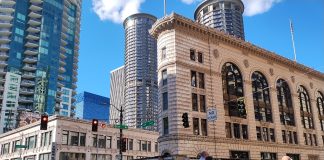 A crosswalk is filled with a dozen pedestrians in downtown Seattle.