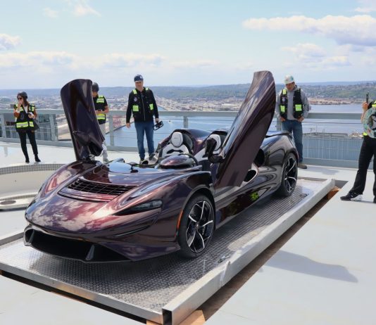 Policy Lab: Tax the Filthy, Stinking Rich McLaren has its butterfly doors up while a half dozen onlookers in yellow vests take picture or admire the car.