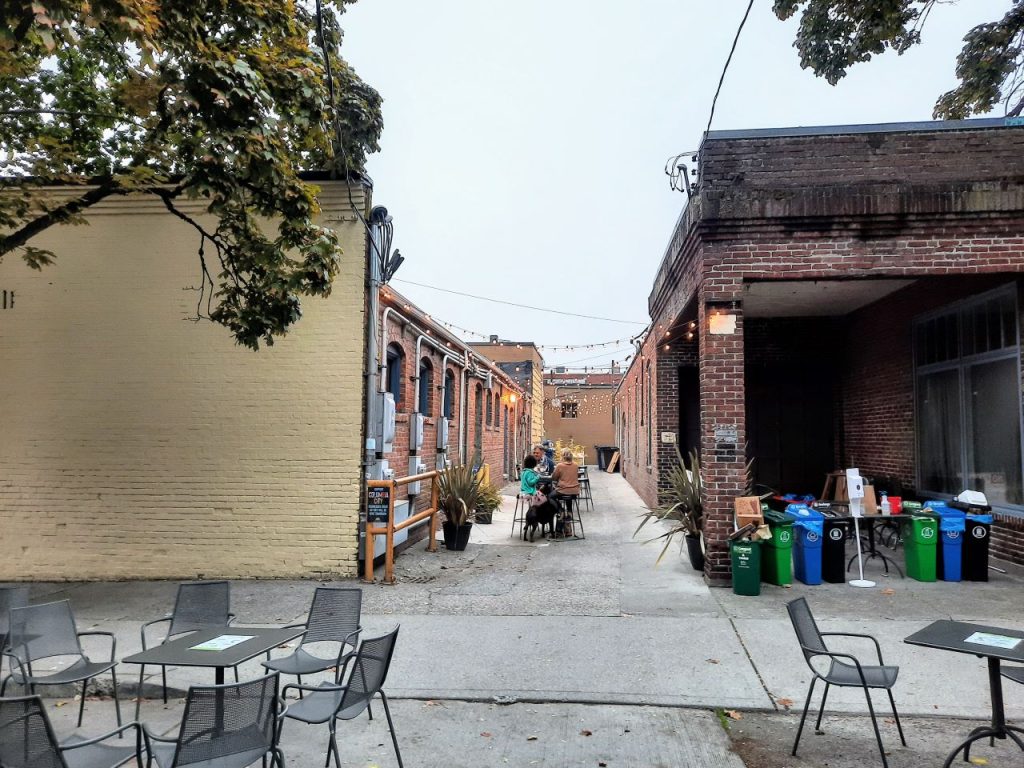 Patrons enjoy the alley that is linedwith seating and strung with lights.