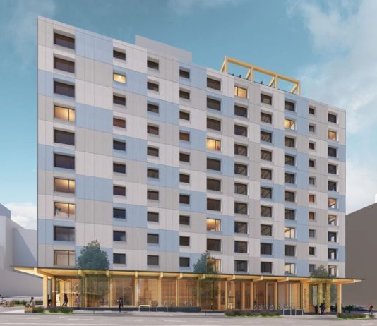 Affordable U District Tower Will Be Seattle’s Tallest Mass Timber Building A rendering shows a side profile with a light gray and blue facade and a simple but elegant window pattern.