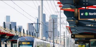 Sound Transit Launches Surveys To Plan South Seattle Link Infill Stations Two riders walked down the platform with the Seattle skyline in the distance.