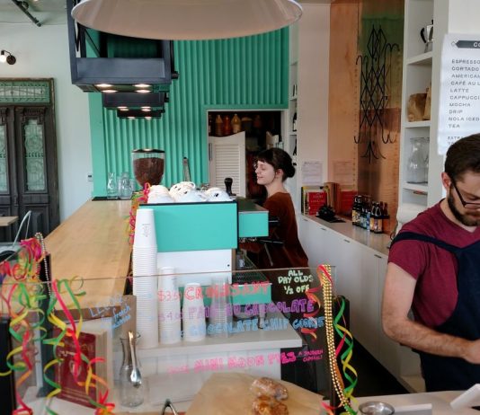 Op-Ed: Seattle Council Won’t Get Away with Gutting Minimum Wage Law Two servers behind the counter at a cafe, one at the register and another at the espresso machine.