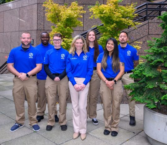 Op-Ed: Katie Wilson’s Civilian Safety Plan Would Unlock More Effective Police Department Seven CARE members wear logoed blue short sleeve shirts that are their official garb. These pose of the step of Seattle City Hall.