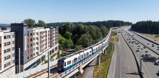 Join The Urbanist’s Lynnwood Link Opening Celebration at Hemlock State Brewing Elevated light rail tracks skirt Interstate 5 and a midrise residential building in Mountlake Terrace.