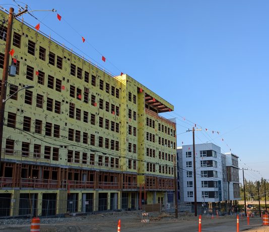 Ferguson Transition Team: Transit-Oriented Development Should Be ‘Top Priority’ An 8 story building under construction near a similarly sized building that is already completed.