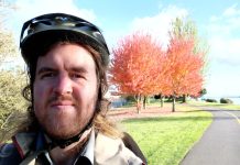 Ryan Packer Talks Vision Zero, Traffic Safety on Hacks and Wonks Podcast Ryan Packer in a bike helmet along a bike path with an autumn-colored tree behind