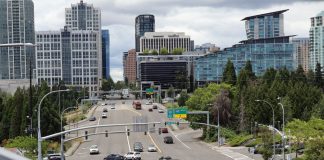A high angle view of wide, car-choked 8th Avenue looking toward I-405 and the towers of Downtown Bellevue.