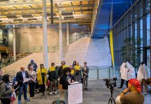 Seattle Rejects Capital Gains Proposal, but Progressive Tax Time Is Nigh Shemona Moreno is at the lectern with a dozen advocates holding signs in defense of JumpStart investments. Two advocates wear ghost costumes with cop hats representing the ghost cop positions that mayor and council prioritizes for funding.