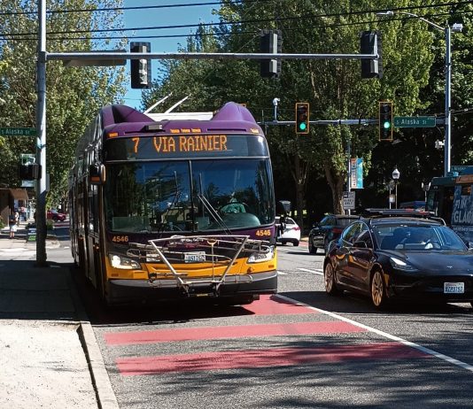 King County Metro Testing Onboard Cameras to Cite Bus-Lane Violators A Route 7 bus comes down Rainier Avenue on a sunny day in a red bus lane