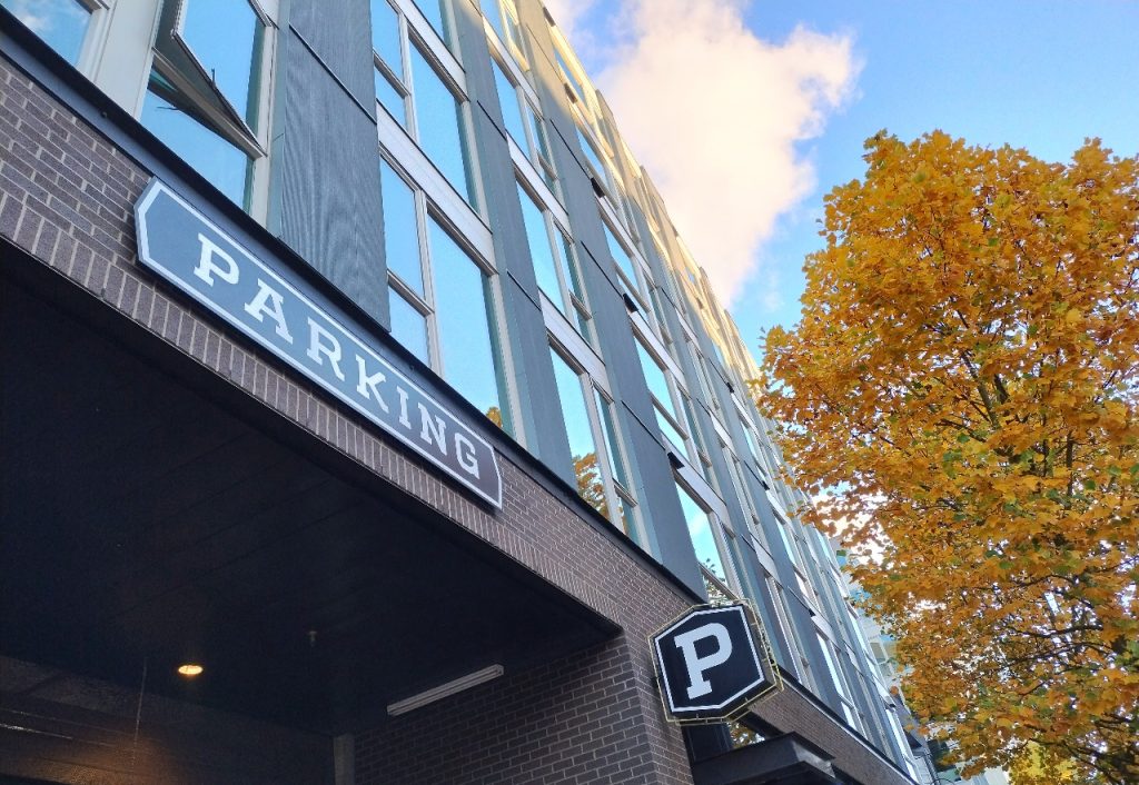 A sign on an apartment building indicating the parking entrance