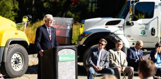 Roger Millar standing at a podium for a photo op