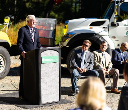 WSDOT Secretary Millar Issues Departing Warning to Policymakers Roger Millar standing at a podium for a photo op