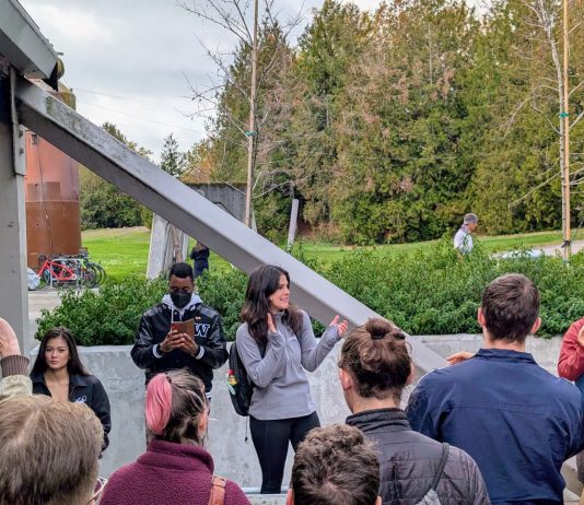 Rinck Retools Housing Affordability Bonus with More Density Alexis and Shaun stand in a picnic area with trees and the pipes and beams of Gas Works in the background.