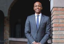 Urbanist Girmay Zahilay Touts Inclusive Approach in County Executive Run Zahilay wears a suit and blue tie and poses next to a brick wall.