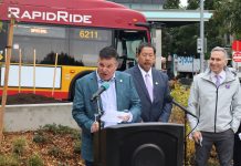 Spotts to Leave SDOT Just as New Transportation Levy Gets Rolling Greg Spotts standing at a podium with Bruce Harrell looming over and a RapidRide bus behind