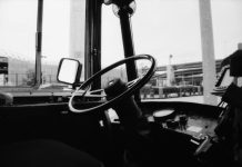 The View From Nathan’s Bus: Shawn Yim and Keeping Transit Safe An empty driver seat in a Metro bus with a highway overpass in the background