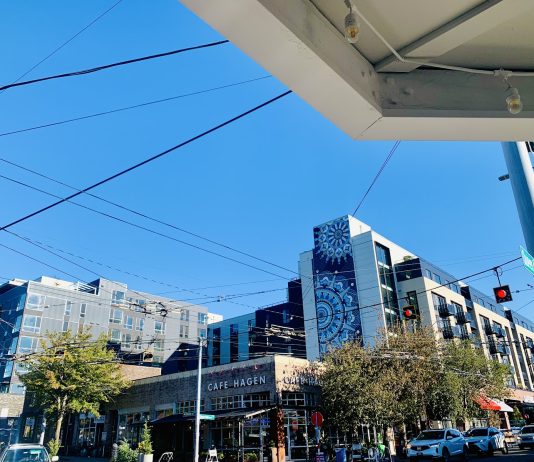 Op-Ed: Queen Anne Must Embrace New Neighbors Rather than Fear Housing Cafe Hagen is on the corner with a seven-story building in the background.