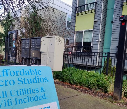 Lawmakers Reach Rent Stabilization Compromise A sign in front of an apartment building advertising "Affordable Micro Studios" with utilities and wifi included