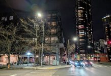 Join The Urbanist for February 3 Meetup with House Our Neighbors Teku Tavern and the view east up Denny Way with skyscrapers shining in the night in the background.