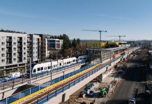 Downtown Redmond Light Rail Opening Set for May 10 A train in testing arriving at Downtown Redmond, with buildings under construction behnind
