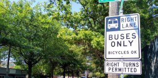 Bellevue Pushes to Open Up Bus-Only Lanes to Private Shuttles A red bus lane in the Rainier Valley with a sign reading "buses only, right turns permitted"
