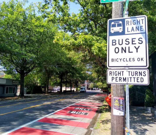 Bellevue Pushes to Open Up Bus-Only Lanes to Private Shuttles A red bus lane in the Rainier Valley with a sign reading "buses only, right turns permitted"