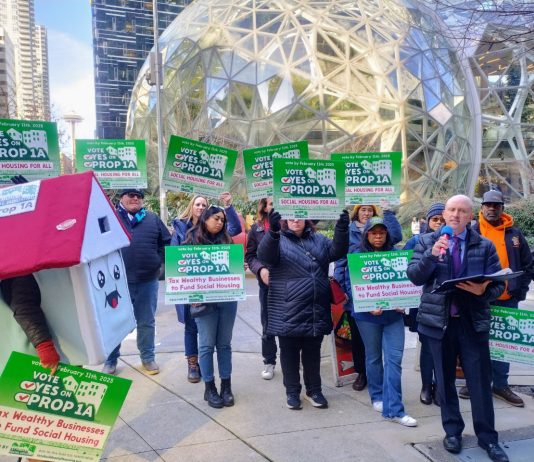 Last-Minute Flood of Corporate Cash Seeks to Derail Social Housing Proposition 1A A house mascot and a dozen sign wielding advocates standing in front of the glass spheres.