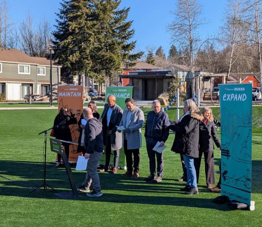 Constantine’s King County Parks Levy Proposal Would Expand Trails, Programming A line of eight officials stand in front of banners that say Maintain, Enhance, and Expand.