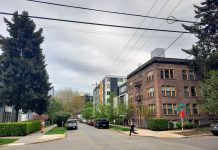 Op-Ed: 10 Reasons Seattle Adding 30 Neighborhood Centers Is Smart Planning A jogger crosses an intersection with a large tree on the corner and a row of apartment buildings of various ages.