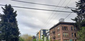 Op-Ed: 10 Reasons Seattle Adding 30 Neighborhood Centers Is Smart Planning A jogger crosses an intersection with a large tree on the corner and a row of apartment buildings of various ages.