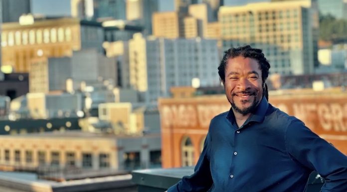 OPCD Further Trims Corridor Upzones in Newly Unveiled Seattle Zoning Maps Rico is a Black man with braids and a button up shirt posing in front of the Seattle skyline