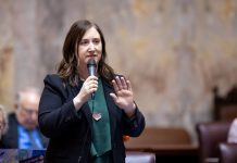 Op-Ed: Wealth Tax on Megarich Would Invest in Washington State’s Future Frame holds a microphone on the floor of senate chambers.