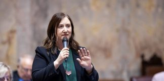 Op-Ed: Wealth Tax on Megarich Would Invest in Washington State’s Future Frame holds a microphone on the floor of senate chambers.