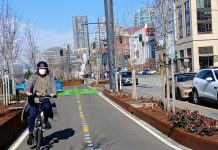 Seattle’s Waterfront Bike Path Opens After Long Wait A person on a Brompton folding bike wearing a mask and biking south on Alaskan Way's bike lane near Seneca Street